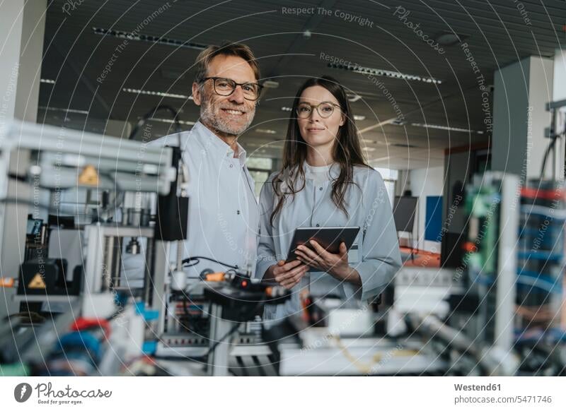 Confident scientists standing by machinery in laboratory color image colour image indoors indoor shot indoor shots interior interior view Interiors science