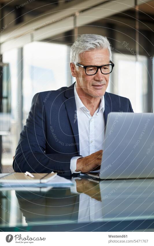 Businessman working in office, using laptop Concentration concentrating concentrated using a laptop Using Laptops At Work Office Offices desk desks Business man
