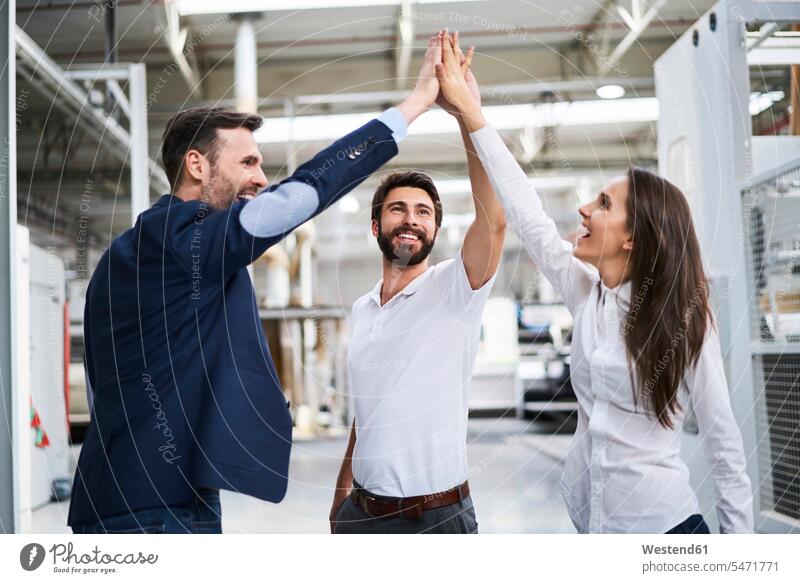 Happy businessman and employees high fiving in a factory Occupation Work job jobs profession professional occupation blue collar blue collar worker