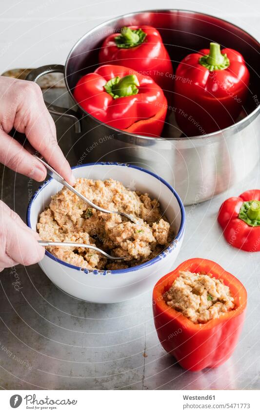 Hands of man preparing stuffed bell peppers with spelt indoors indoor shot indoor shots interior interior view Interiors elevated view High Angle View