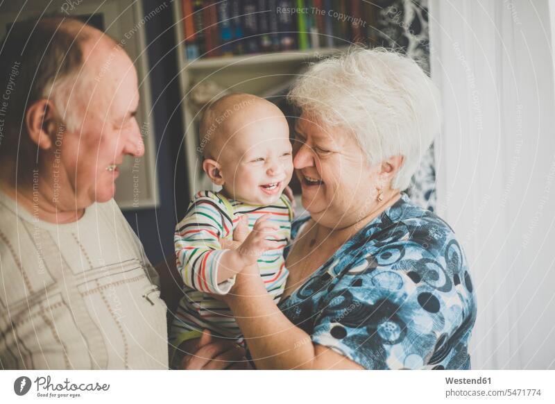 Happy grandparents holding their baby grandson human human being human beings humans person persons caucasian appearance caucasian ethnicity european Group