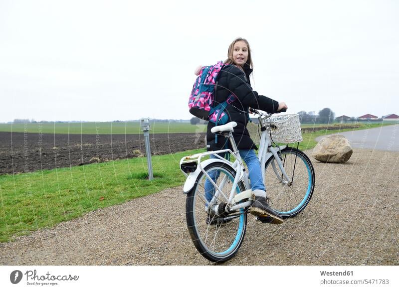 Girl with backpack and bicycle in rural landscape rucksacks backpacks back-packs landscapes scenery terrain girl females girls country countryside bikes