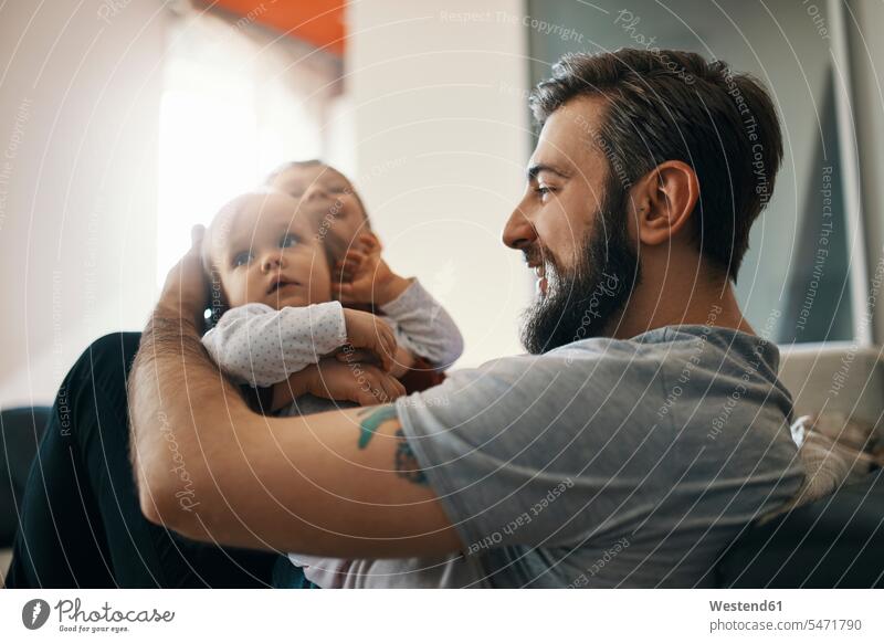 Happy father with baby girl and little son together at home pa fathers daddy dads papa baby girls female happiness happy sons manchild manchildren parents