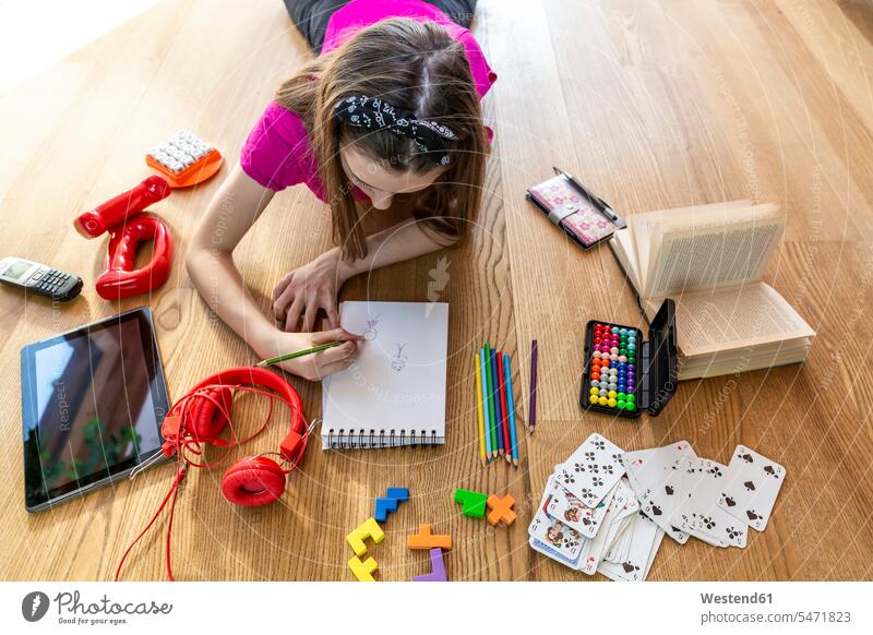 Girl lying on floor with play equipment, drawing on pad human human being human beings humans person persons caucasian appearance caucasian ethnicity european 1