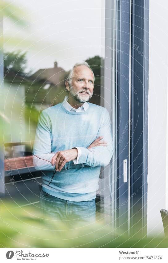 Mature man looking out of terrace door men males view seeing viewing patio door French window Adults grown-ups grownups adult people persons human being humans