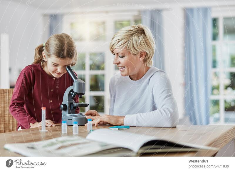 Mother and daughter using microscope at home microscopes daughters mother mommy mothers ma mummy mama child children family families people persons human being