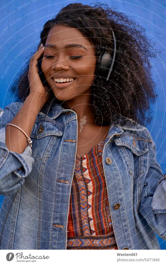 Portrait of smiling young woman listening music with headphones human human being human beings humans person persons African black black ethnicity coloured 1