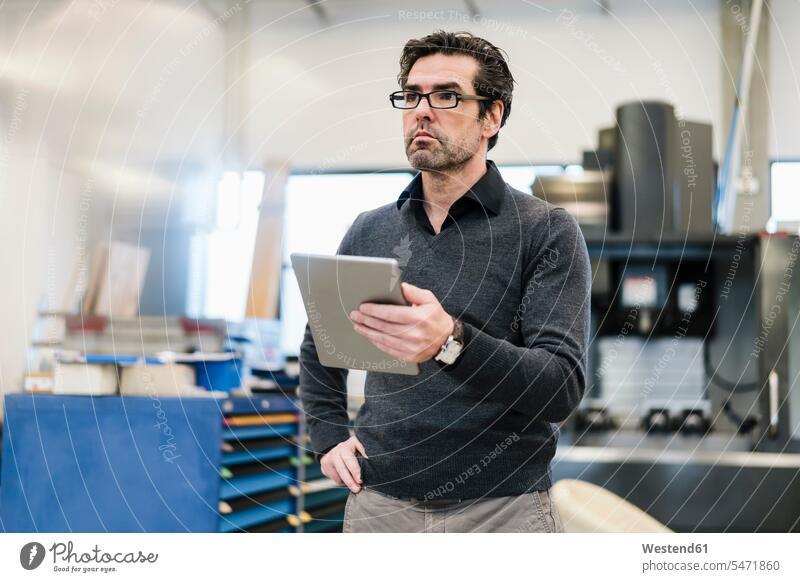 Businessman holding tablet in a factory human human being human beings humans person persons caucasian appearance caucasian ethnicity european 1 one person only