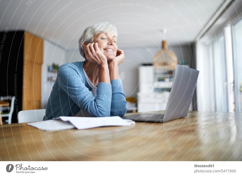 Thoughtful senior woman with hand on chin sitting at home color image colour image indoors indoor shot indoor shots interior interior view Interiors day