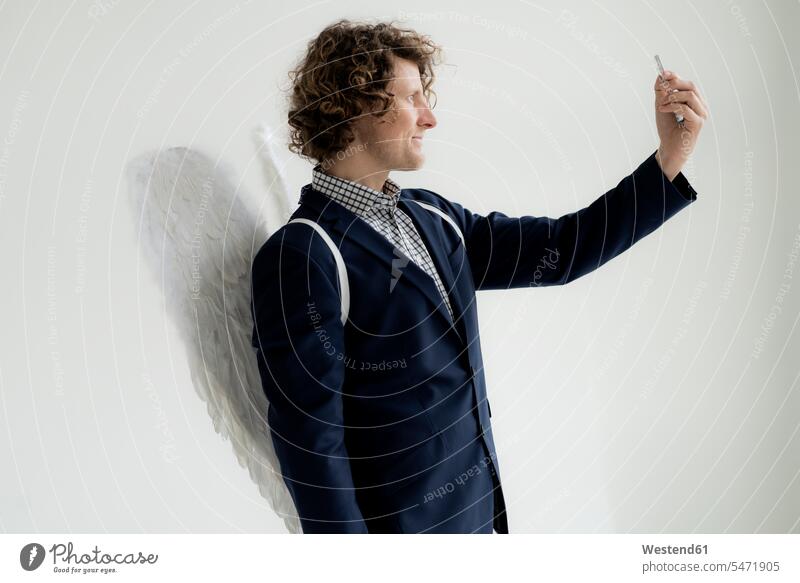 Businessman wearing angel's wings, taking a selfie self-portrait Self Portrait Photography Photographing Self Self-Portrait Photography selfies angels