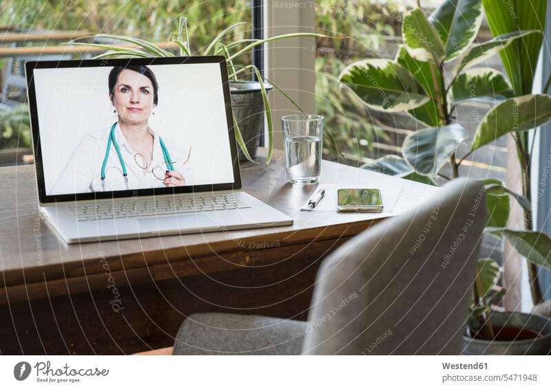Female doctor on laptop screen for video call at home color image colour image indoors indoor shot indoor shots interior interior view Interiors day