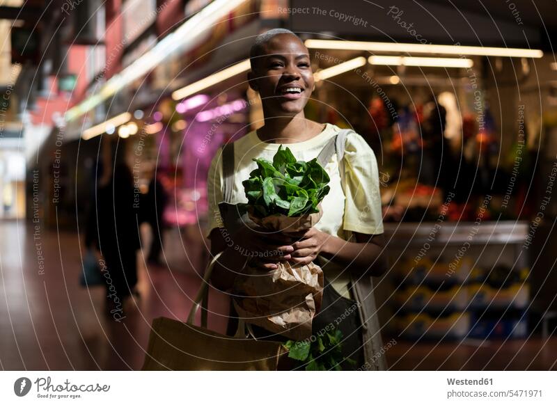 Portrait of happy woman holding paper bag in a market hall human human being human beings humans person persons client clientele clients customers short hairs