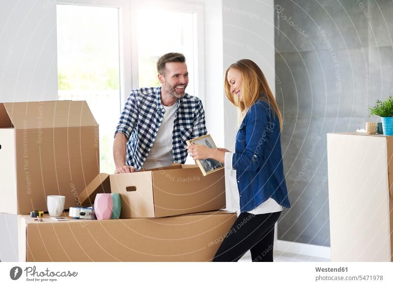 Couple moving into new flat packing cardboard boxes packing case packing cases flats apartment apartments moving house move Moving Home couple twosomes