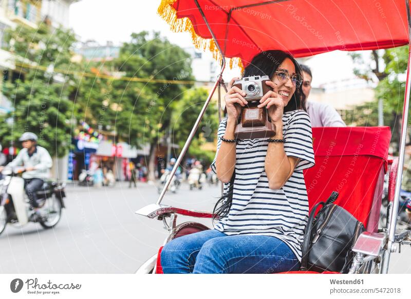 Vietnam, Hanoi, young woman with old-fashioned camera on a riksha cameras females women Riksha photographing Adults grown-ups grownups adult people persons