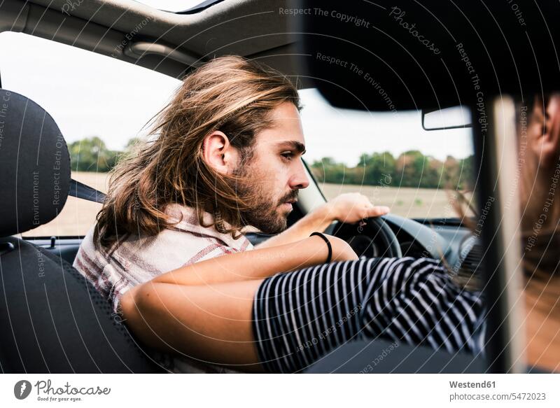 Young man looking at woman in a car automobile Auto cars motorcars Automobiles eyeing couple twosomes partnership couples motor vehicle road vehicle
