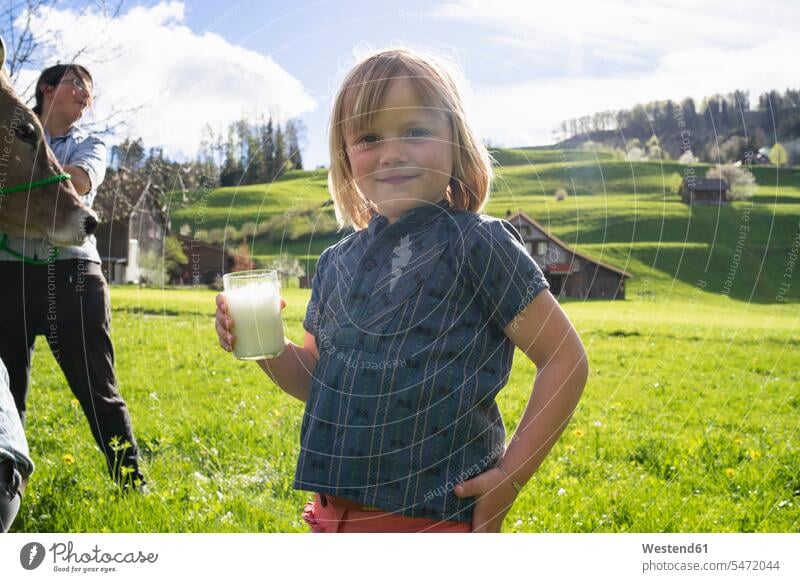 Portrait of smiling girl holding a glass of fresh milk on pasture human human being human beings humans person persons caucasian appearance caucasian ethnicity