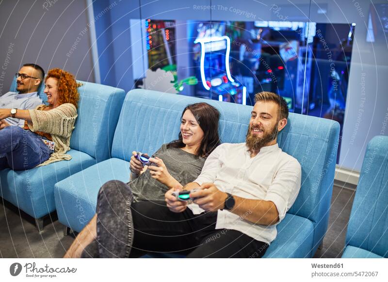 Happy friends playing and having fun in an amusement arcade human human being human beings humans person persons caucasian appearance caucasian ethnicity