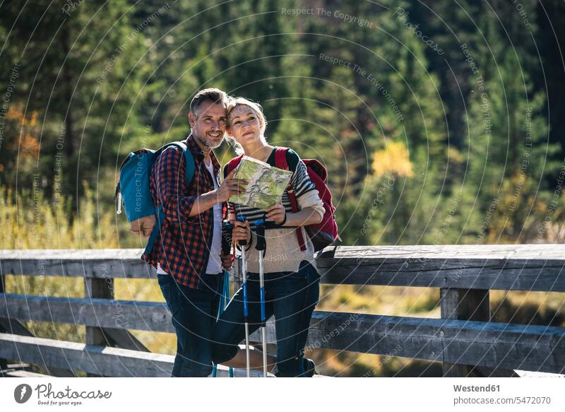 Austria, Alps, happy couple on a hiking trip standing on a bridge caucasian caucasian appearance caucasian ethnicity european White - Caucasian mature men