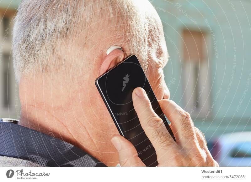 Close-up of senior man with hearing aid using smartphone on the phone call telephoning On The Telephone calling Smartphone iPhone Smartphones senior men