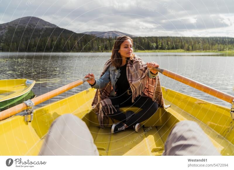 Finland, Lapland, woman wearing a blanket in a rowing boat on a lake boats lakes rowboat rowing boats rowboats females women Blanket Blankets vessel