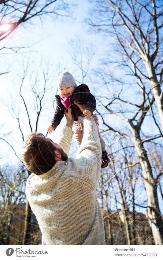 Father lifting up happy daughter in park happiness lift up father fathers daddy dads papa daughters parks parents family families people persons human being