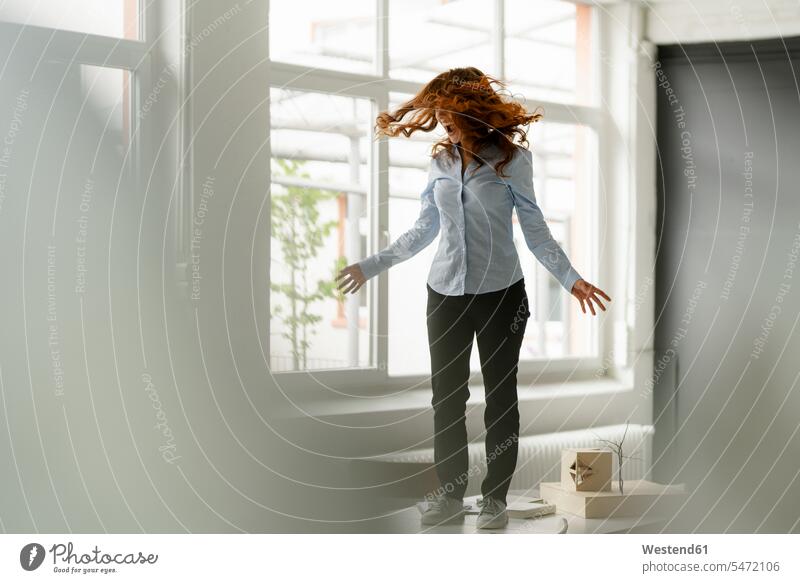 Redheaded woman standing on desk in a loft moving and screaming human human being human beings humans person persons caucasian appearance caucasian ethnicity