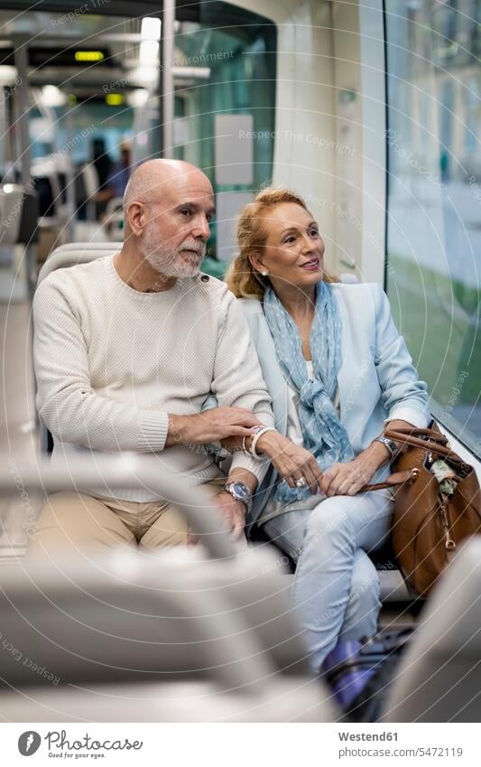 Senior couple sitting in a tram Seated twosomes partnership couples senior couple elder couples senior couples tramway tramways streetcars trams people persons