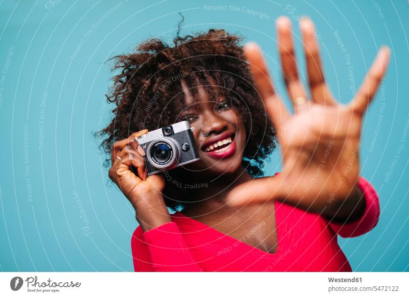 Portrait of happy young woman holding vintage camera in studio human human being human beings humans person persons African black black ethnicity coloured