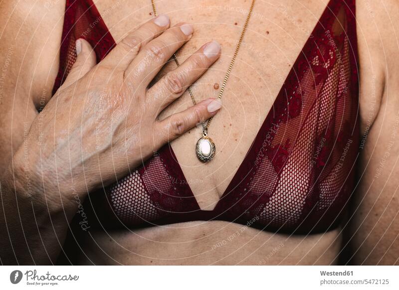 Close-up of a senior woman wearing a bra and a necklace human human being human beings humans person persons caucasian appearance caucasian ethnicity european 1