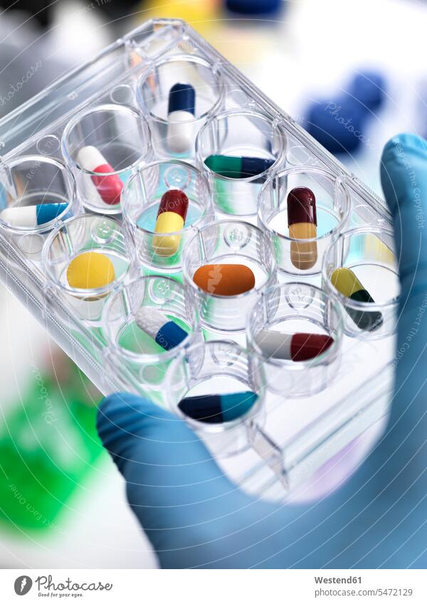 Pharmaceutical Research, Scientist holding a multi well plate containing drugs to be tested in the laboratory sorting researcher research scientist tablet