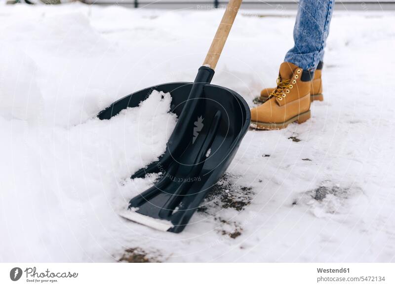 Crop view of woman clearing walkway with snow shovel seasons hibernal stand chilly Cold Temperature Cold Weather free time leisure time location shot