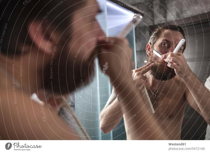 Portrait of bearded man looking at his mirror image while shaving men males shave eyeing reflexion reflection Adults grown-ups grownups adult people persons