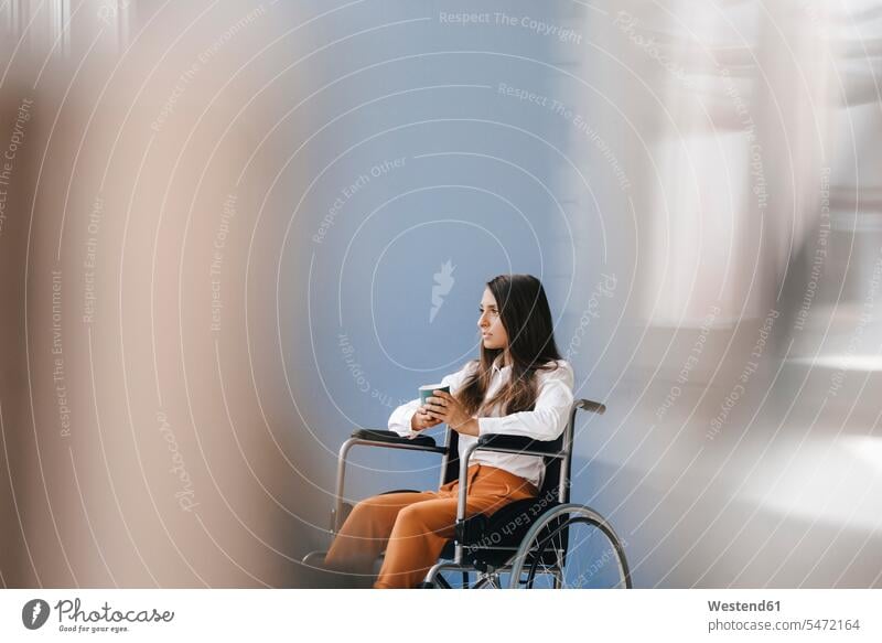 Young handicapped woman sitting in wheelchair, looking worried females women serious earnest Seriousness austere helpless Helplessness Seated Coffee wheel chair