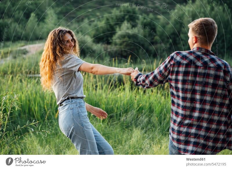 Romantic couple spending time in nature, holding hands natural world hand in hand Falling In Love young couple young couples young twosome young twosomes