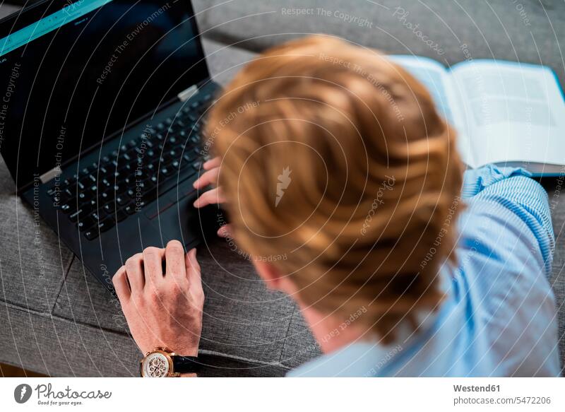 Male freelance worker typing on laptop at home color image colour image indoors indoor shot indoor shots interior interior view Interiors day daylight shot