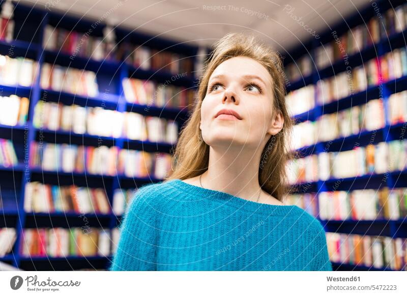 Portrait of teenage girl in a public library looking for book books portrait portraits Teenage Girls female teenagers watching Teenager Teens people persons