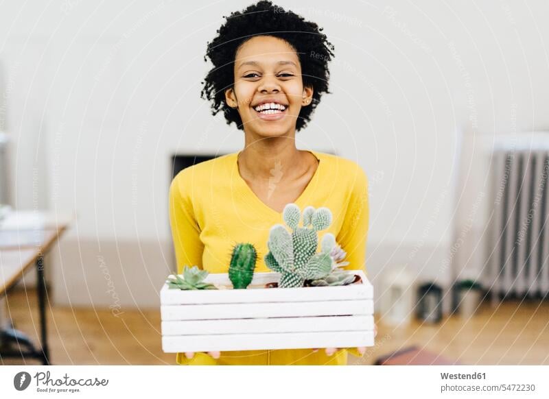 Happy young woman holding flower box with cacti smiling smile happiness happy Cactus Cactaceae Cacti Cactuses flower boxes young women Plant Plants females