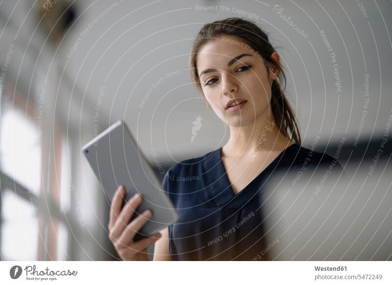 Portrait of young businesswoman with digital tablet in office human human being human beings humans person persons caucasian appearance caucasian ethnicity
