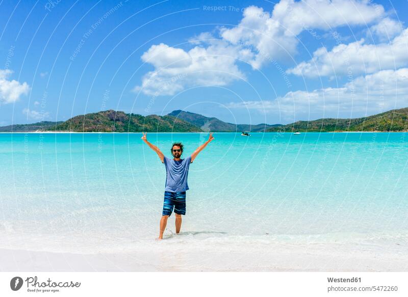Australia, Queensland, Whitsunday Island, man with raised arms standing at Whitehaven Beach beach beaches men males Adults grown-ups grownups adult people