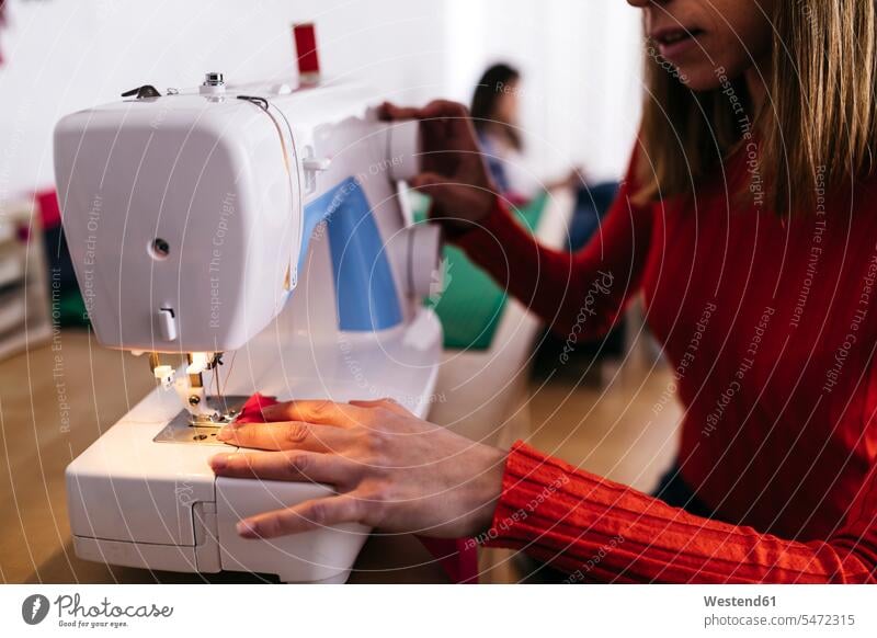 Fashion designer in studio using sewing machine fashion fashionable designers female designer female designers studios woman females women sewing machines