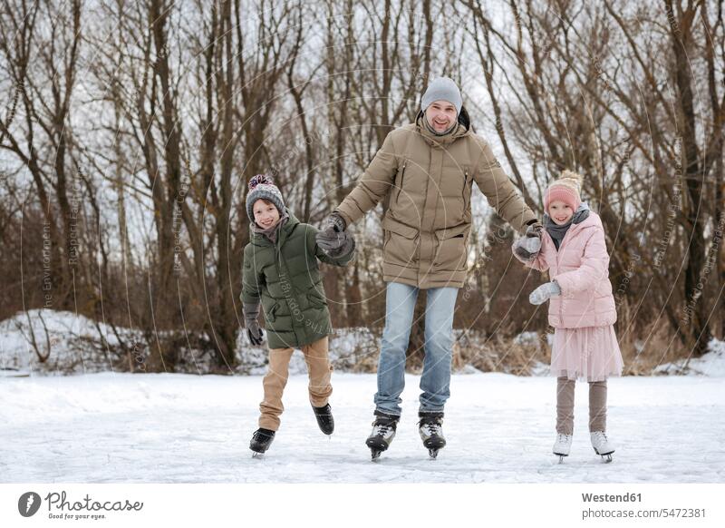 Two happy siblings skating together with father on ice human human being human beings humans person persons caucasian appearance caucasian ethnicity european