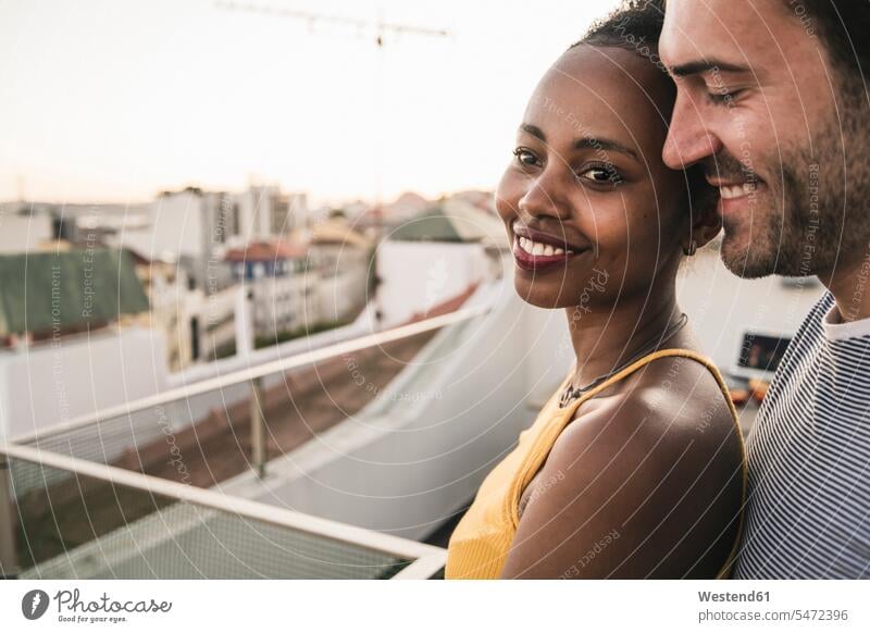 Portrait of affectionate young couple on rooftop in the evening human human being human beings humans person persons African black black ethnicity coloured