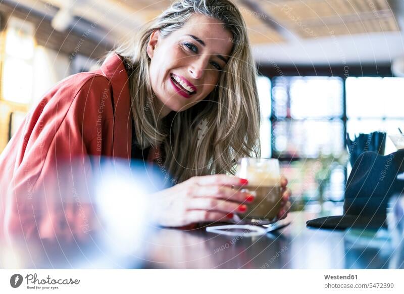 Portrait of happy woman having a drink at the counter of a bar females women counters bars Drink beverages Drinks Beverage portrait portraits Adults grown-ups