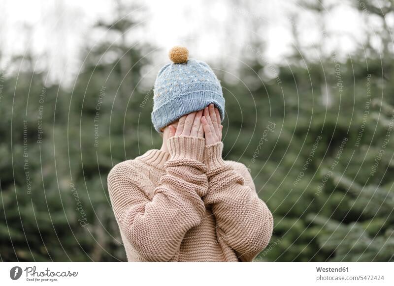 Boy wearing woolen hat covering his face boy boys males woolly hat Wooly Hat Knit-Hat Knit Hats wool cap child children kid kids people persons human being