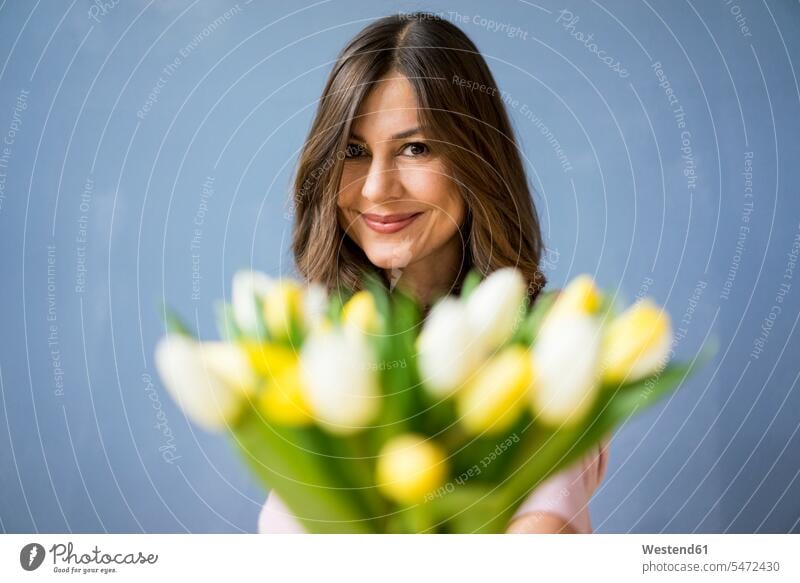Portrait of smiling woman holding bunch of tulips portrait portraits Tulip Tulipa Tulip Flower Tulip Flowers Tulips Liliaceae Tulipa females women smile