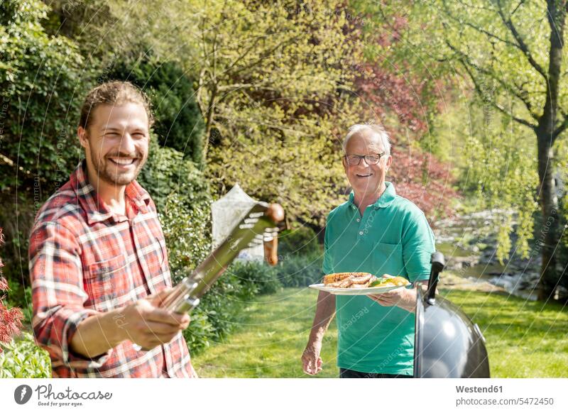 Portrait of happy man on a family barbecue in garden generation barbecue grill barbecue grills Barbeque Grill Barbecuing grilling hold smile summer time