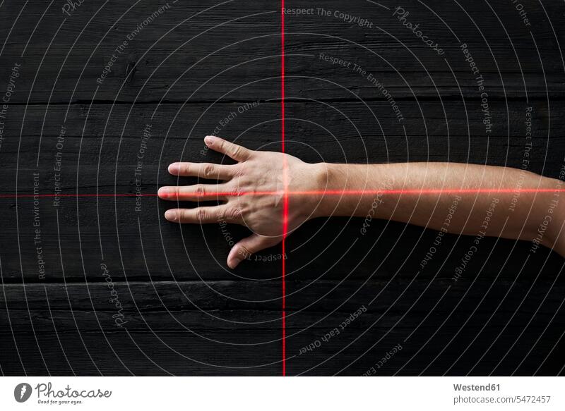 Human hand getting scanned by red light rays bird's eye view from above Birds-Eye Perspective top view Birds-Eye View overhead view cross crosses beams of light