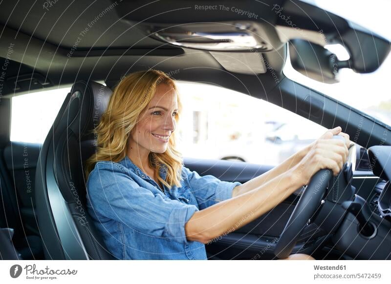 Smiling woman driving car females women automobile Auto cars motorcars Automobiles drive smiling smile Adults grown-ups grownups adult people persons