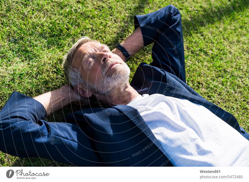 Senior businessman lying in grass with closed eyes business life business world business person businesspeople Business man Business men Businessmen relax