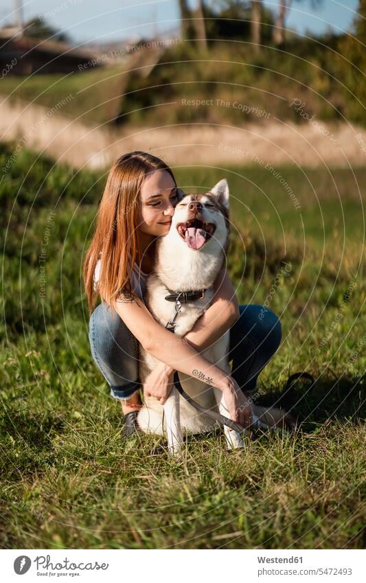 Happy young woman hugging her dog on a meadow animals creature creatures domestic animal pet Canine dogs T- Shirt t-shirts tee-shirt smile embrace Embracement